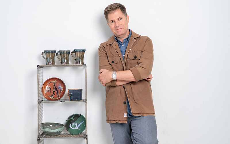 Brian showing his hands covered in clay